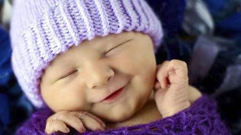 Baby wearing a crocheted purple hat