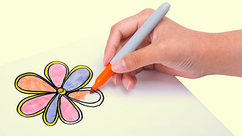 A right hand drawing with an orange marker on Shrinky Dink transparency