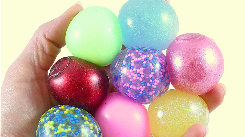 Homemade polymer balls filled with beads, glitter and other colorful items.