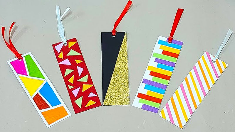 Photo of five decorated bookmarks setting on a gray table.